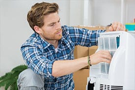 air conditioning tech repairing unit