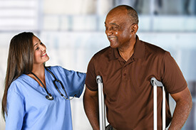 Practical-Nursing Patient Care Assistant helping man on crutches