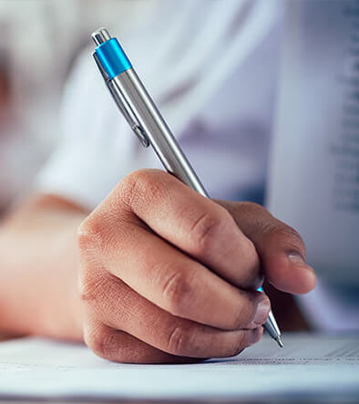students hand holding pen for class test