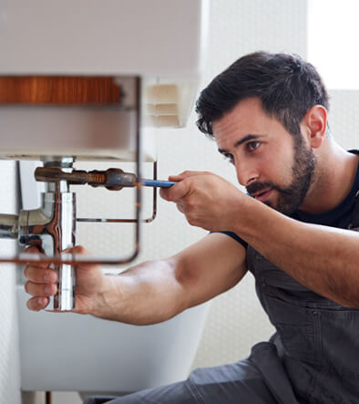 Plumber fixing a leaky pipe